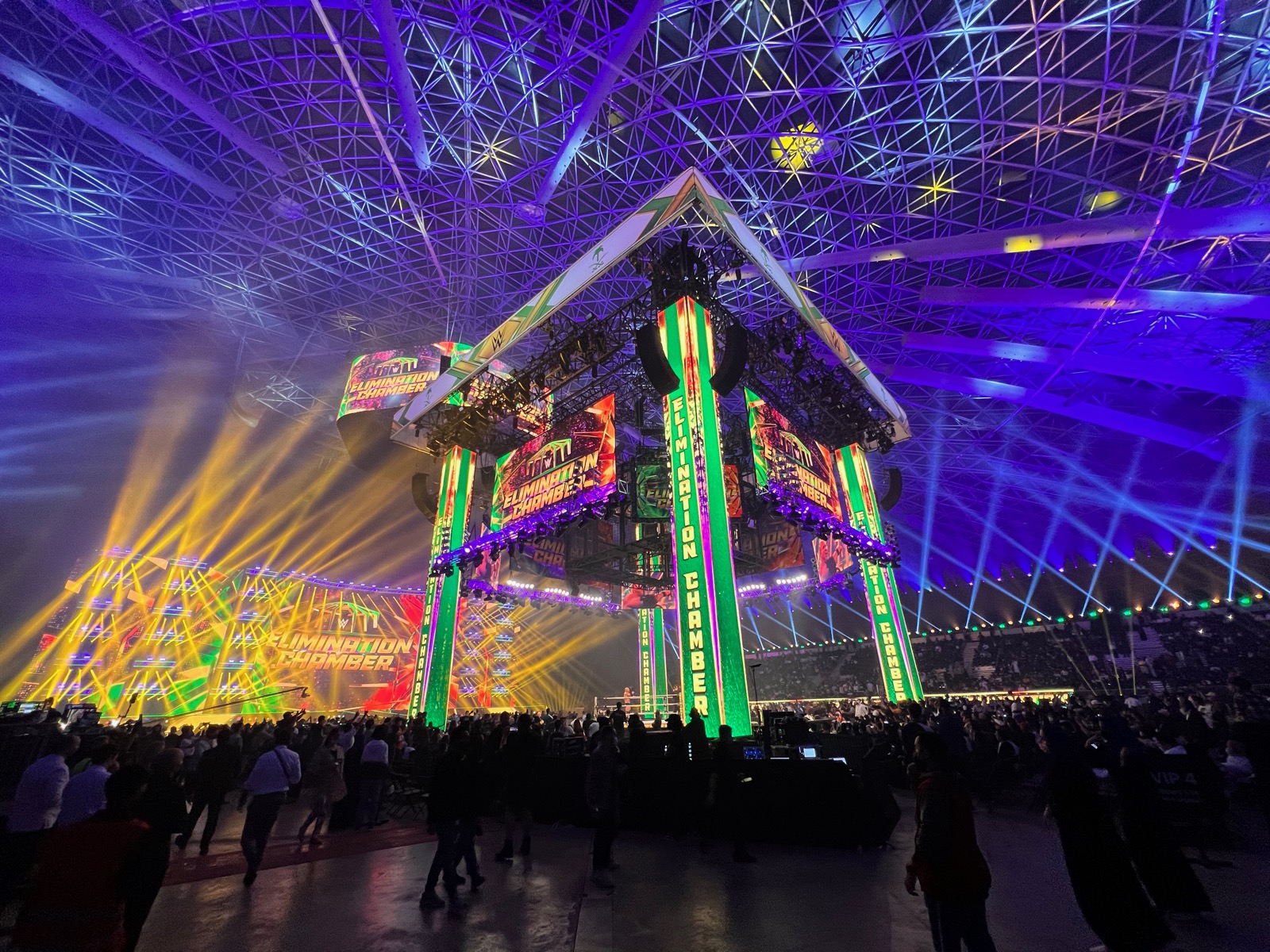 Towering Elimination Chamber stage structure with lasers in a domed arena